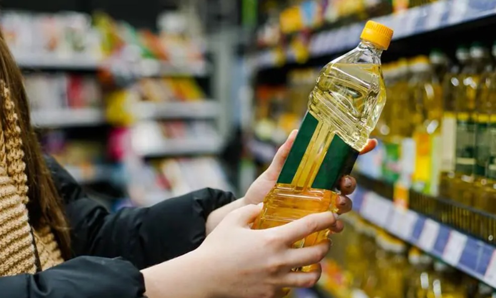 A person holding a bottle of seed oil - thinking about Seed Oils in Baby Food